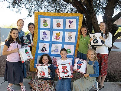 The Reach Out Girls show off their quilt and pillows